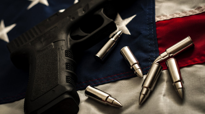 Background check in America: pistola con proiettili e bandiera americana
