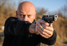 Indagine Eurispes sul possesso di armi in Italia Indagine Eurispes sul possesso di armi in Italia: uomo impugna pistola