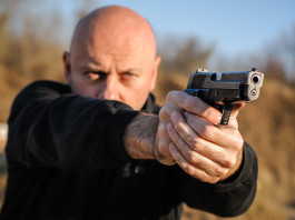 Indagine Eurispes sul possesso di armi in Italia Indagine Eurispes sul possesso di armi in Italia: uomo impugna pistola