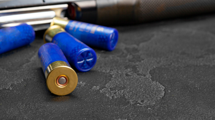 Munizioni in piombo per il tiro sportivo: munizioni con bossolo blu davanti a fucile