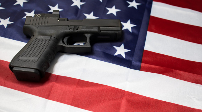 Quanti background check in America a fine luglio 2023: pistola su bandiera americana