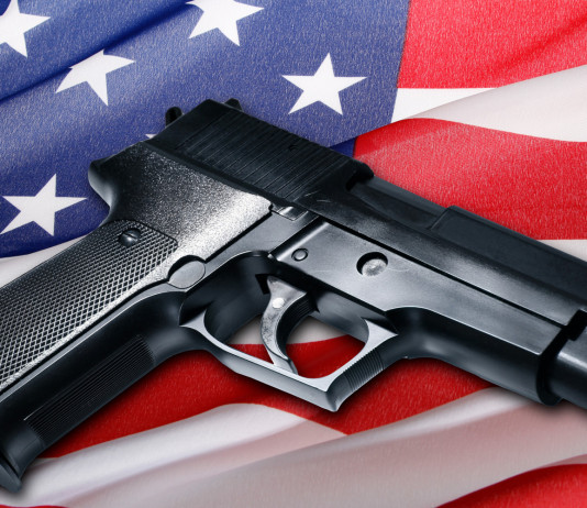 Quanti background check in America a due terzi del 2023? Quanti background check in America a due terzi del 2023: pistola su bandiera americana