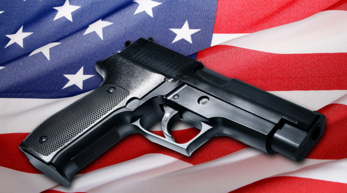 Quanti background check in America a due terzi del 2023: pistola su bandiera americana