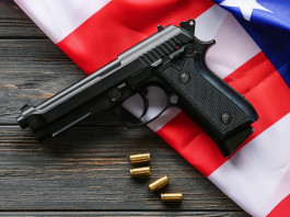 Armi vendute in America, la situazione a metà novembre Armi vendute in America, la situazione a metà novembre: pistola con proiettili insieme a bandiera americana