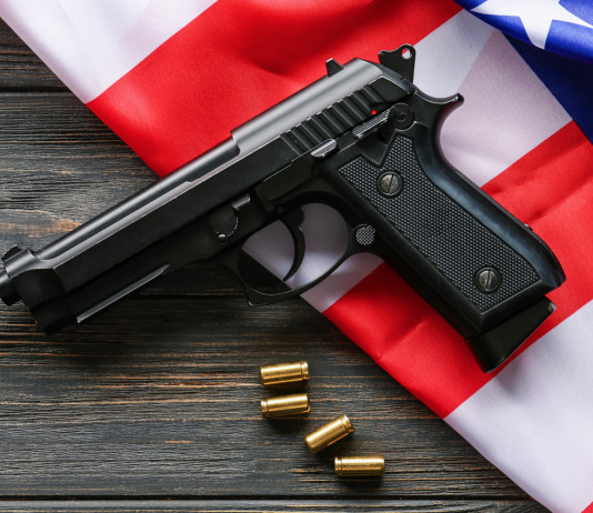 Armi vendute in America, la situazione a metà novembre Armi vendute in America, la situazione a metà novembre: pistola con proiettili insieme a bandiera americana
