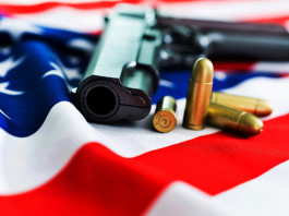 Mercato delle armi in America, la situazione a inizio dicembre Mercato delle armi in America, la situazione a inizio dicembre: pistola con proiettili su bandiera americana