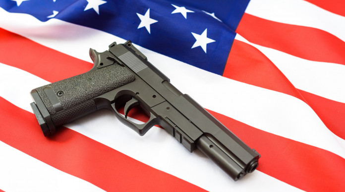 Com’è partito il mercato delle armi in America nel 2024: pistola su bandiera americana