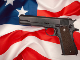 Quanti background check in America nel 2023? Quanti background check in America nel 2023? pistola semiautomatica su bandiera americana