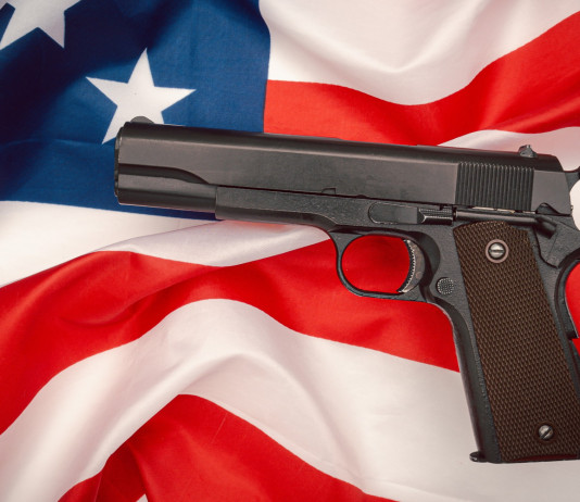 Quanti background check in America nel 2023? Quanti background check in America nel 2023? pistola semiautomatica su bandiera americana