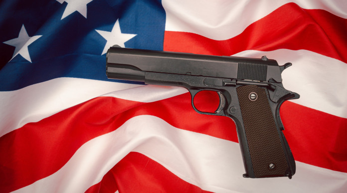 Quanti background check in America nel 2023? pistola semiautomatica su bandiera americana