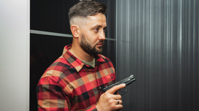 Difendersi con le armi in casa: il sondaggio Demos - giovane uomo con pistola per legittima difesa