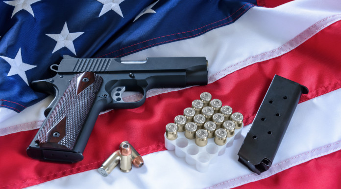 Mercato delle armi in America: la situazione a inizio maggio - pistola con munizioni su bandiera americana