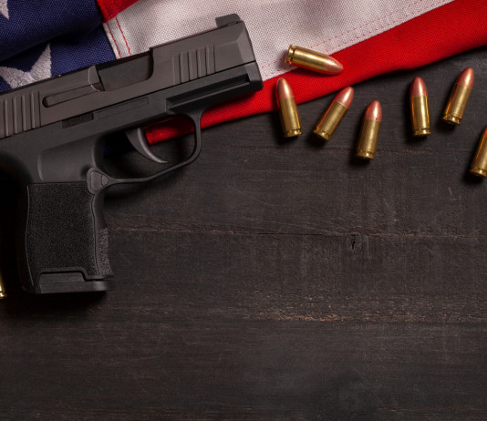 Come sta andando il mercato delle armi in America? Come sta andando il mercato delle armi in America? pistola e munizioni su bandiera americana