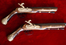 Omessa custodia di armi antiche in collezione: la sentenza del Tar Omessa custodia di armi antiche in collezione: la sentenza del Tar - due pistole antiche su panno rosso