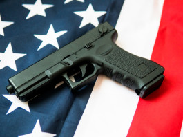 Quanti background check chiesti in America nei primi dieci mesi del 2025? Quanti background check chiesti in America nei primi dieci mesi del 2025 - pistola su bandiera americana