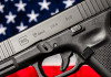 Quanti background check richiesti in America nel 2025? Quanti background check richiesti in America nel 2025 - pistola glock g19 gen 5 davanti a bandiera americana, stelle e strisce