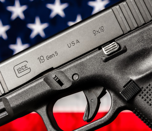 Quanti background check richiesti in America nel 2025? Quanti background check richiesti in America nel 2025 - pistola glock g19 gen 5 davanti a bandiera americana, stelle e strisce