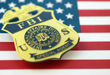 Quanti background check richiesti in America tra gennaio e luglio 2026? Quanti background check richiesti in America tra gennaio e luglio 2026 - distintivo Fbi su bandiera americana