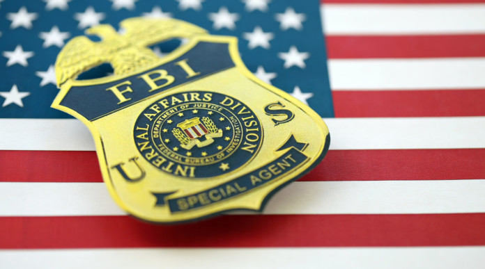 Quanti background check richiesti in America tra gennaio e luglio 2026 Quanti background check richiesti in America tra gennaio e luglio 2026 - distintivo Fbi su bandiera americana