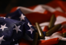 Quanti background check richiesti in America nei primi otto mesi del 2026? Quanti background check richiesti in America nei primi otto mesi del 2026 - bossoli su bandiera americana