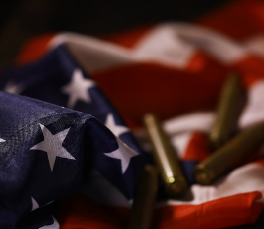 Quanti background check richiesti in America nei primi otto mesi del 2026? Quanti background check richiesti in America nei primi otto mesi del 2026 - bossoli su bandiera americana